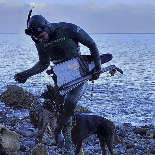 Pescador con una captura y un fusil Rocco