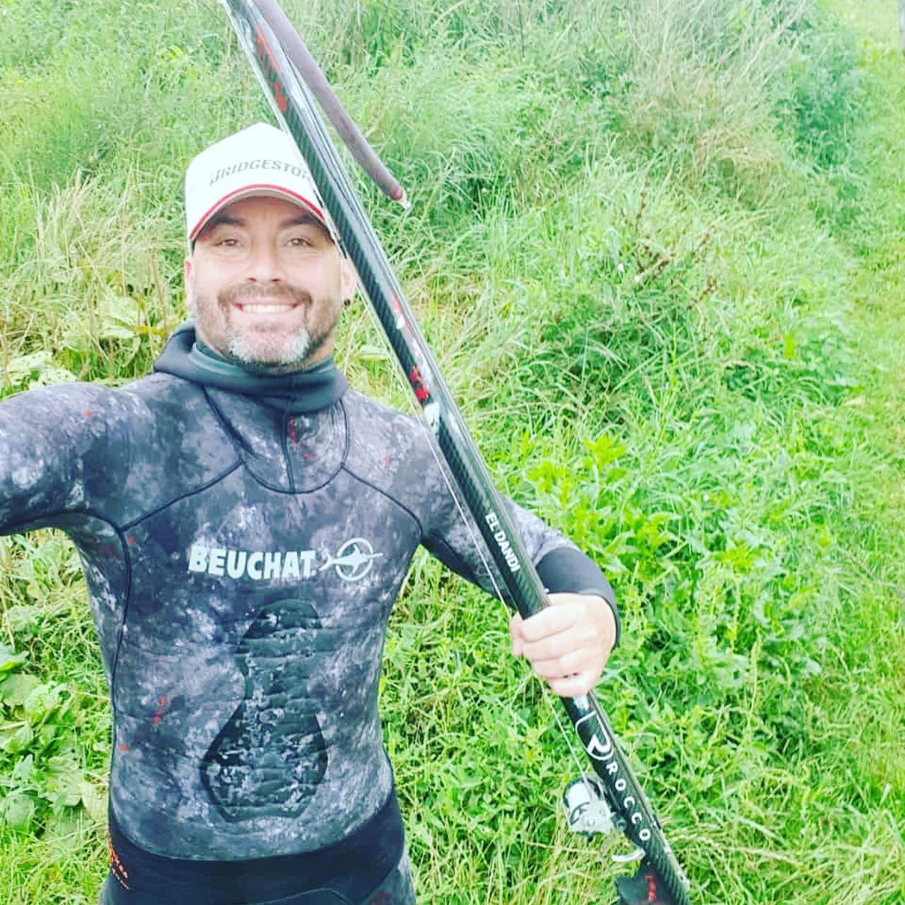 Pescador con una captura y un fusil Rocco