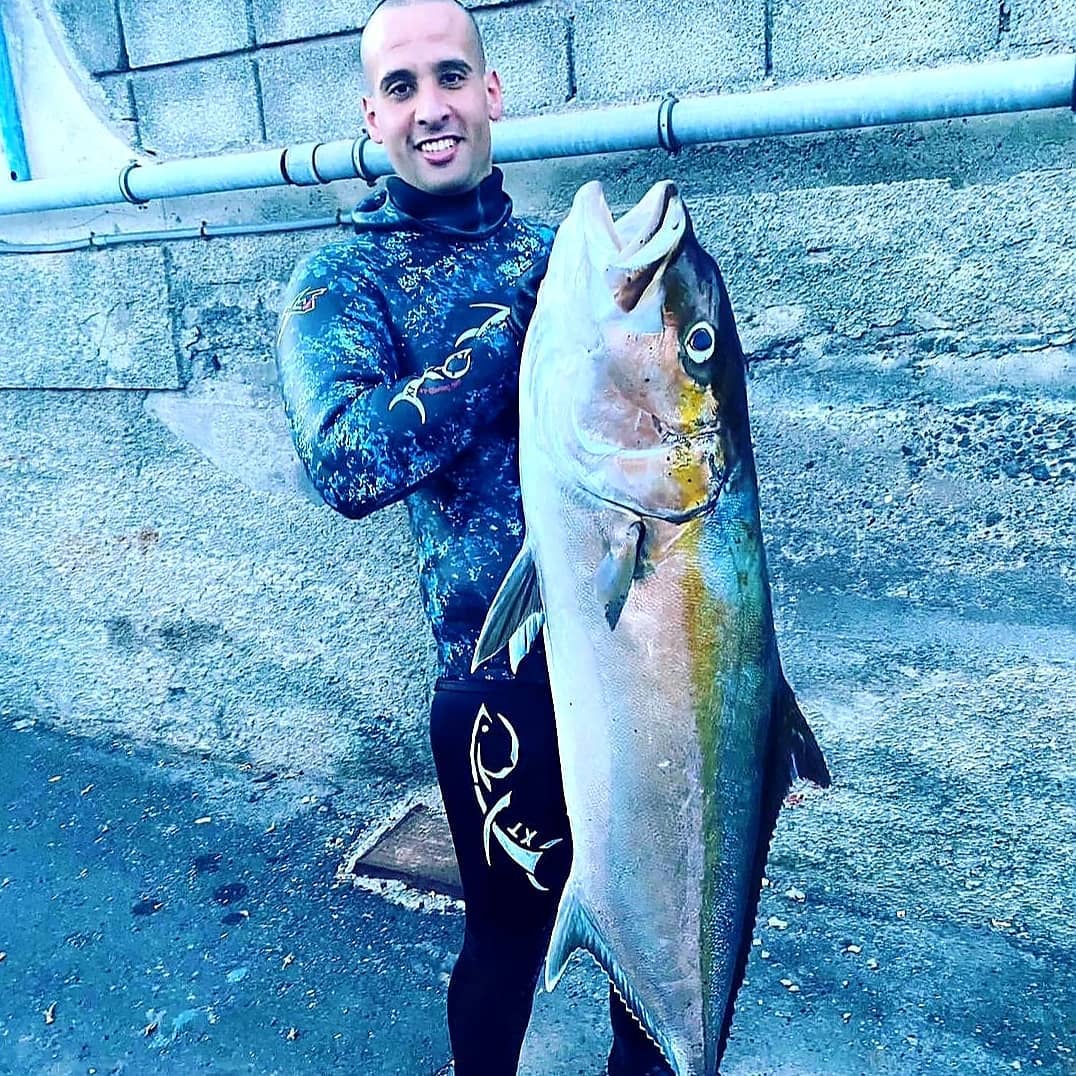 Pescador con una captura y un fusil Rocco