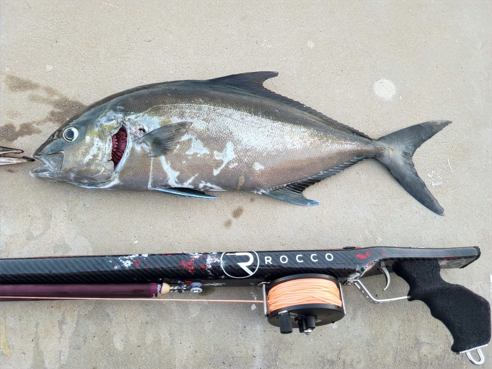 Pescador con una captura y un fusil Rocco