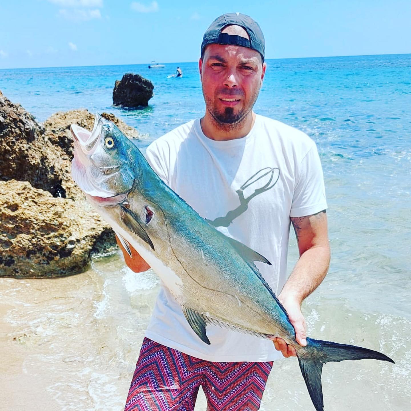 Pescador con una captura y un fusil Rocco