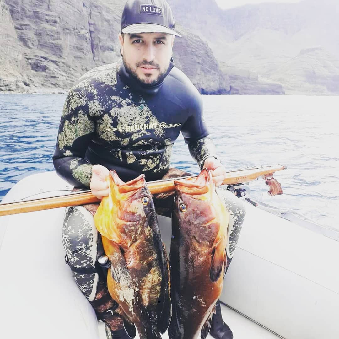 Pescador con una captura y un fusil Rocco